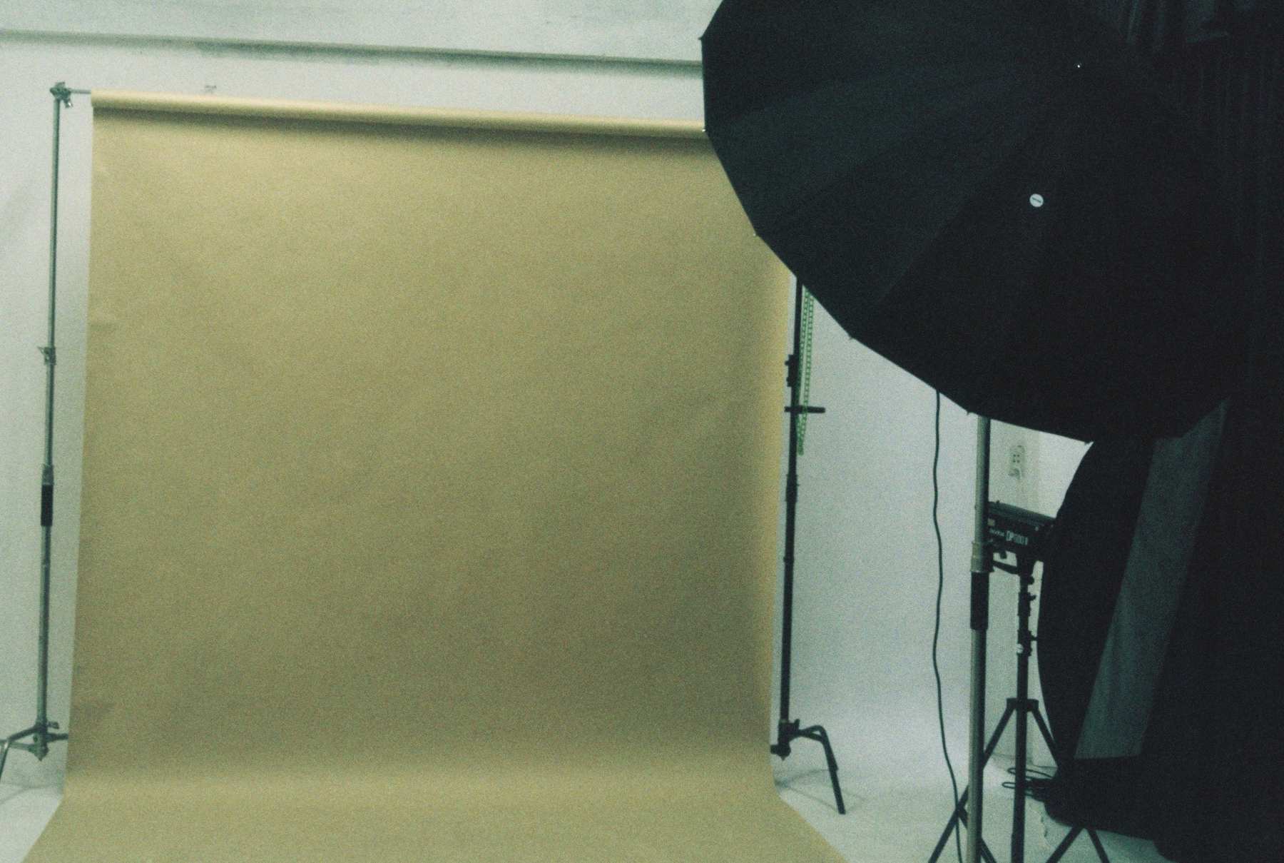 An empty photography studio — seamless backdrop, lights and stands, set up and waiting