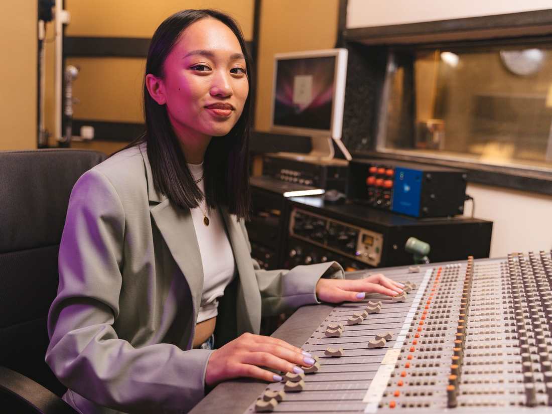 A producer at a mixing console in a recording studio